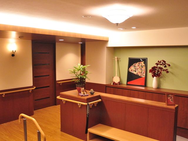 温かみのある室内廊下 廊下 温かみのある照明と木製の手すりが設置された落ち着いた雰囲気の廊下です。安全に配慮した設計がされています。