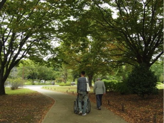 公園で散歩する人々 公園 広々とした中庭を散策する方々の姿が心地よい。自然の中でリフレッシュできる空間がございます。