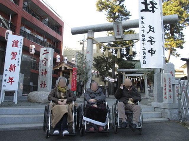 車椅子の人々と鳥居 初詣 車椅子の方々が心地よい屋外を満喫しています。自然と触れ合い、リラックスした時間を過ごせる場所です。