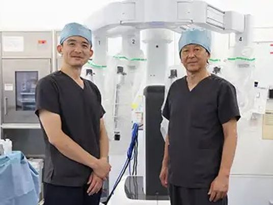 手術支援機器の前のスタッフ