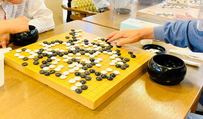 囲碁を囲む手と碁盤