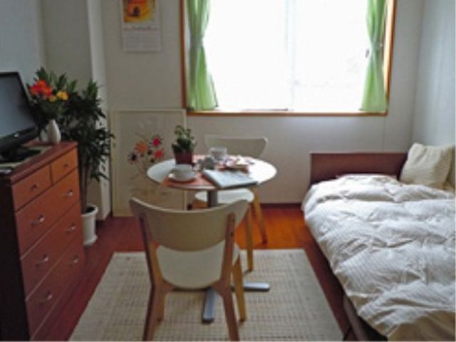 居心地の良い居室 居室 日差しの入る窓辺に飾られた花とテーブルが、温かみのある居住スペースを作り出しています。ベッド脇には、個人の嗜好に合わせた家具が揃えられています。