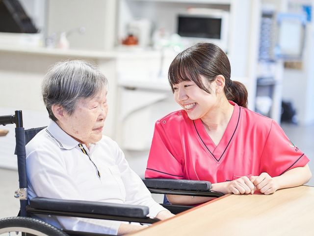 交流するスタッフと利用者 ラウンジ 明るい空間でスタッフが利用者と笑顔で交流しています。温かい雰囲気が働く魅力です。