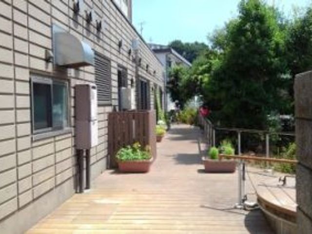木製の通路と緑の庭園 廊下 自然に囲まれた木製の通路です。心地よい環境でリラックスできる場を提供しています。