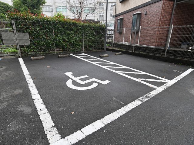 バリアフリーの駐車スペース 駐車場 車椅子マークが示す専用駐車場があり、車椅子の方も安心してアクセスできる設計になっています。
