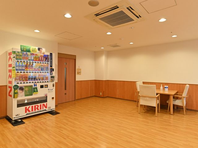 休憩スペースの自動販売機 休憩スペース 自動販売機が設置されており、心地よい休憩空間が提供されています。テーブルと椅子も完備され、一息つける場所です。