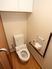 個室の温水洗浄トイレ。壁には手すりとナースコールボタンが設置されているので安心できる。ドアは引き戸式タイプ。