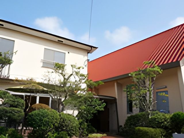 青空の下の建物外観 外観 緑に囲まれた建物で、快適な環境が整っています。明るい空の下で働くことができます。