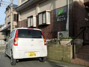 外観と送迎車が見える建物前  