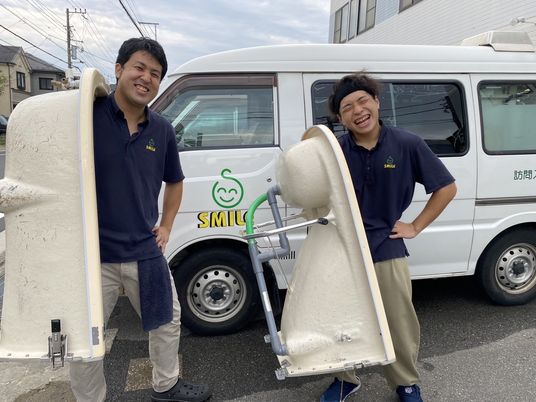 笑顔のスタッフと訪問車両