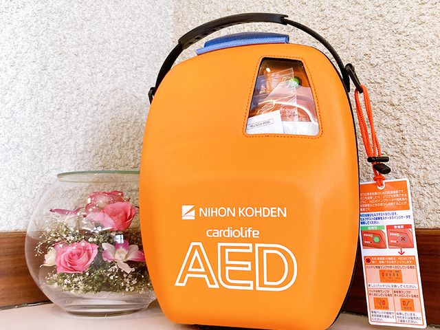緊急用備品の設置場所 中庭 赤いAEDが設置されています。安全管理がしっかりとされていることを確認できます。