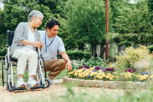 車椅子の利用者とスタッフの庭