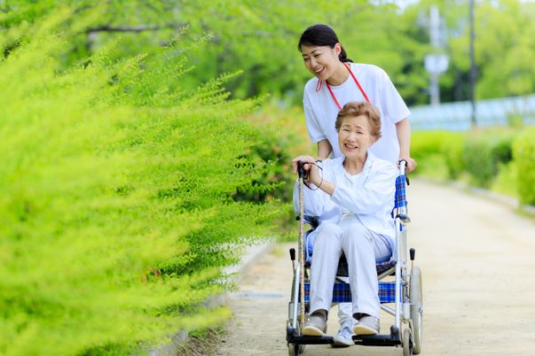 笑顔で車椅子を押すスタッフ