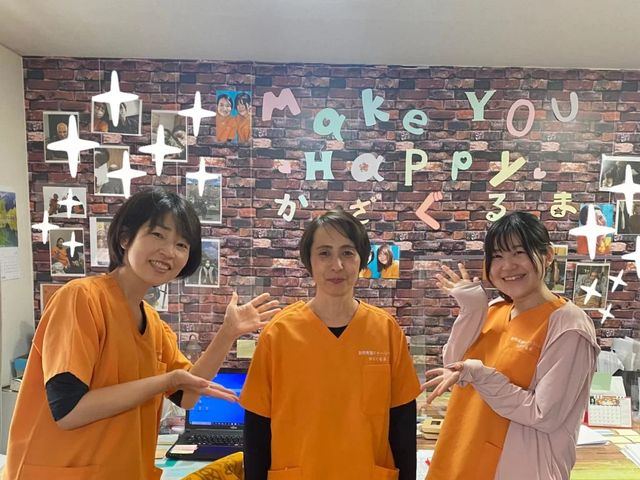 笑顔の職員が並ぶロビー ロビー   明るいロビーで職員の方々が笑顔を見せています。掲示や写真が飾られ、親しみやすい雰囲気です。
