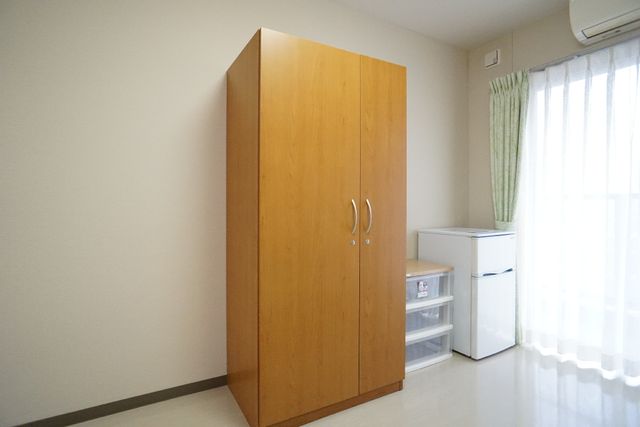 居室のクローゼットと冷蔵庫 居室 居室には収納が充実しており、個々の生活用品を整理しやすいです。また、窓から自然光が差し込む明るい部屋が確保されています。