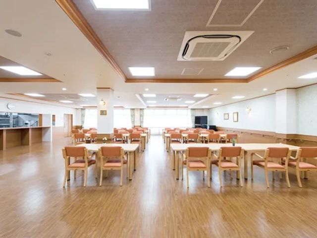 広い食堂の室内 食堂   木目調の床が広がる明るい食堂です。テーブル席がゆったり配置され、落ち着いて食事できそうです。