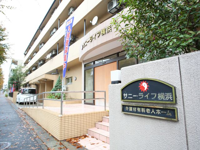 看板のある建物の外観 玄関 暖かみのある色合いで落ち着いた雰囲気を醸し出す建物の入り口です。