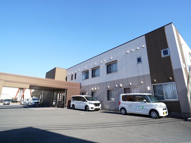 モダンな外観の建物 外観 外には利用者の移動をサポートする車両が停まっており、機能的な造りが印象的です。建物全体から清潔感があり、日当たりもよさそうです。