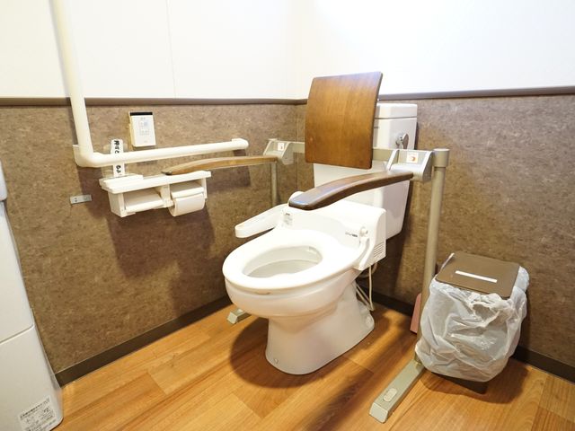 バリアフリーなトイレ設備 廊下 手すり付きで安全に配慮された施設のトイレです。清潔感のある環境で、利用者の快適さが考えられています。
