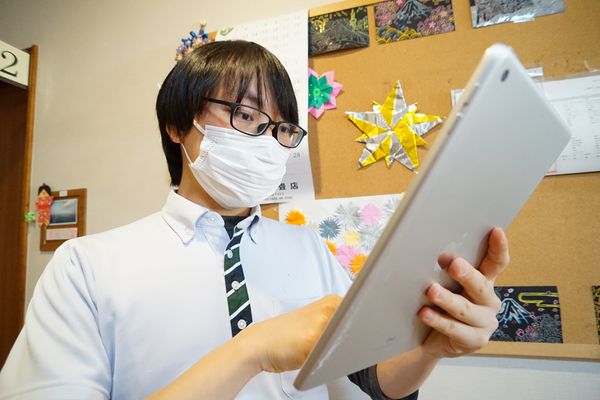 メガネの男性がタブレット操作