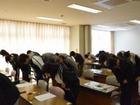 会議室で一斉にお辞儀する人々  