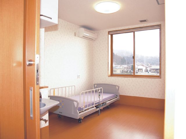 居室のベッドと窓 居室 ゆったりとした空間の居室です。窓からの自然光が心地よい雰囲気を演出し、快適な生活をサポートします。