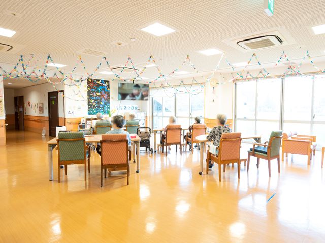明るい広々とした食堂 共有スペース 落ち着いた雰囲気の食堂で、利用者の方々がリラックスしながらくつろいでいます。カラフルな装飾が心地よい交流の場を演出しています。