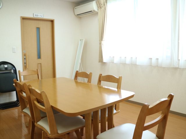快適な食堂の一角 談話室 ゆとりある木製のテーブルが配置された食堂です。日当たりの良い窓際で、穏やかな食事の時間をお過ごしいただけます。