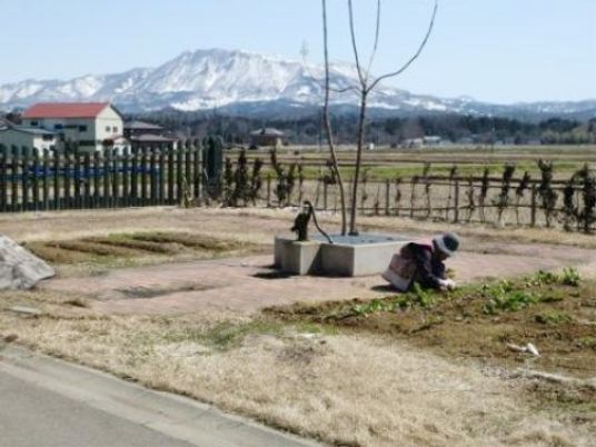 山並みを背景に庭作業