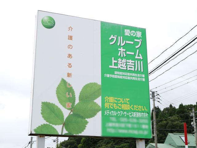 緑の葉のある案内板 看板 視認性に富んだ明瞭な案内板が立てられており、安心感を与えるデザインです。緑豊かな周辺環境も伺えます。