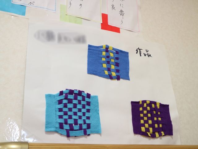 手工芸品が貼られた壁 掲示板 色鮮やかな手工芸品が壁に飾られており、明るく楽しい雰囲気を醸し出しています。創造性を刺激する活動が行われていることがうかがえます。