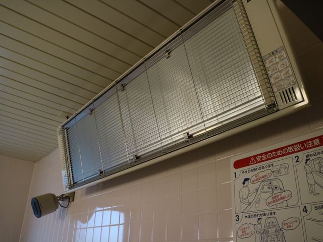 浴室のヒートランプと掲示物 浴室暖房 温かみのあるヒートランプと、安全に配慮した使用方法の掲示が見られます。