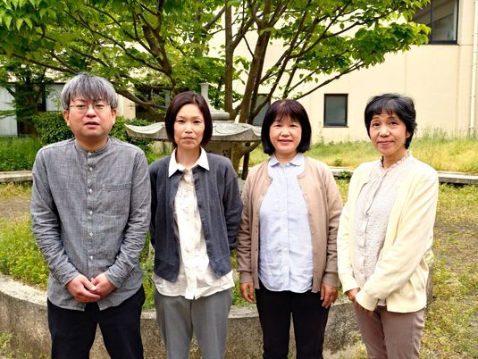 職員4人が並ぶ中庭  