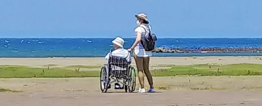 車椅子で海辺を散歩するシーン  