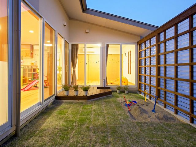 明るい中庭 中庭   大きな窓から室内の様子が見え、明るさを感じる中庭です。砂場や遊具があり、くつろぎやすい空間に見えます。