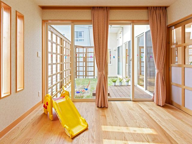 明るい居室と庭先 居室   大きな窓から光が入り、木目調の床が明るく見える居室です。庭に面した出入口があり、開放感のある環境です。