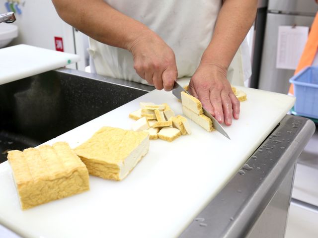 調理中の豆腐の切り分け 厨房 丁寧に食材を扱う手が、利用者の健康を支えています。