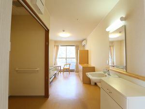 居室の洗面台とベッド
