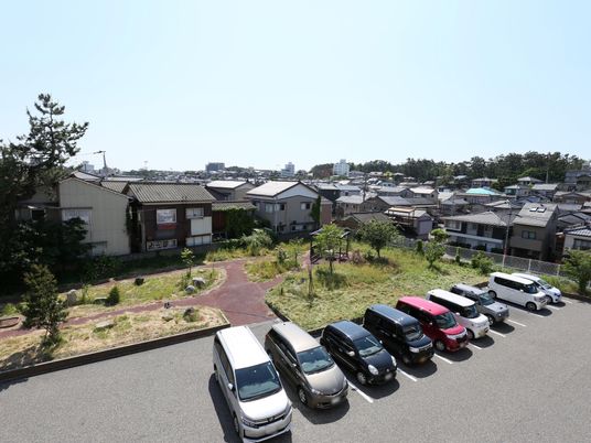 庭と駐車場のある外観