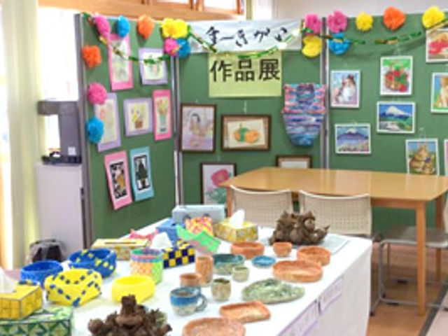 作品展示のスペース 多目的室 カラフルな作品が多く展示されており、温かみのある雰囲気です。利用者の作品を囲んで交流が楽しめます。
