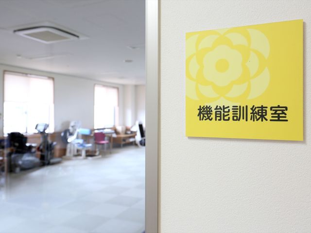 機能訓練室の案内表示 機能訓練室 こちらはリハビリ機器がそろった明るく広々とした機能訓練室です。リハビリをサポートする環境が整っており、スタッフとしての充実感を感じられる場所です。