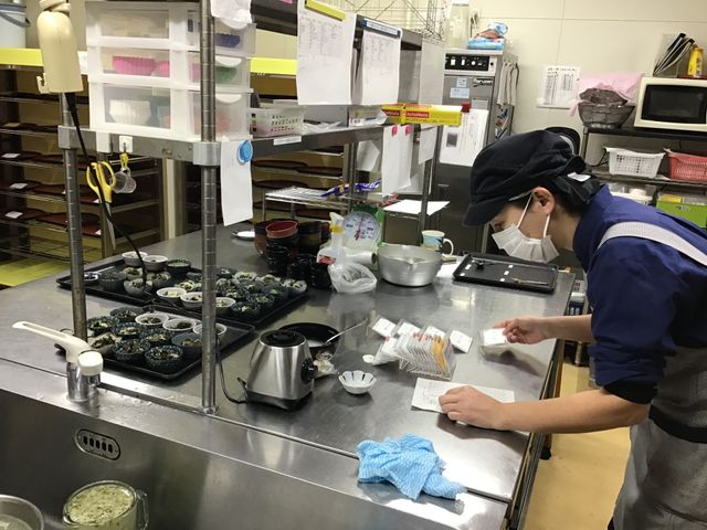 厨房内で丁寧に業務 キッチン 清潔なキッチン環境で、食事の提供を支える大切な役割です。チームワークを大切に業務を進めています。