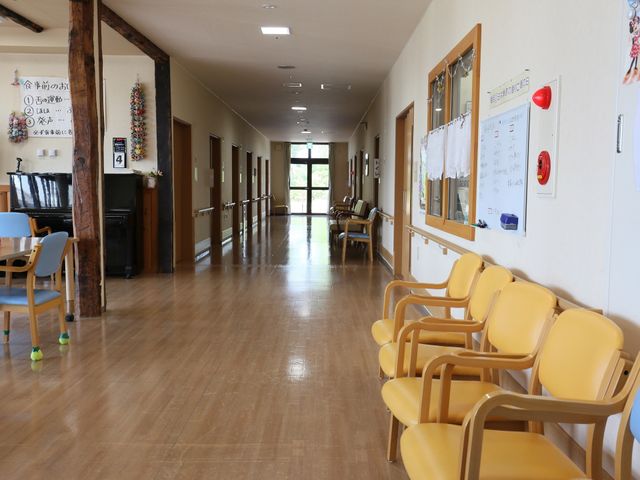明るく広々とした廊下 廊下 木のぬくもりを感じる廊下は、日差しをたくさん受けて温かい雰囲気です。黄色の椅子が並ぶ憩いのスペースも配されています。