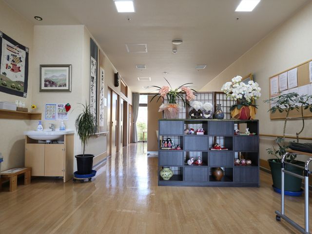 清潔な廊下の風景 玄関ホール きれいに保たれた廊下には、和風の装飾品が飾られており、心地良い環境が整っています。日々の業務にも彩りを添える空間です。