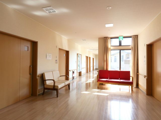 明るい廊下とベンチ 廊下 広々とした通路には日の光が差し込み、待合用のベンチも配置され快適な環境です。安らかな時間が流れる落ち着いた空間が広がっています。