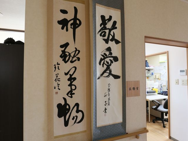 書の掛け軸とオフィス風景 書道作品 和の趣ある掛け軸が、仕事場の雰囲気を和らげています。コミュニケーションも取りやすそうな明るい空間です。