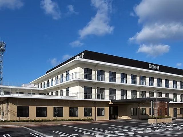 建物外観 外観   青空の下に、白とベージュの落ち着いた建物が見えます。駐車スペースも整っており、働く場の全体像が分かりやすいです。