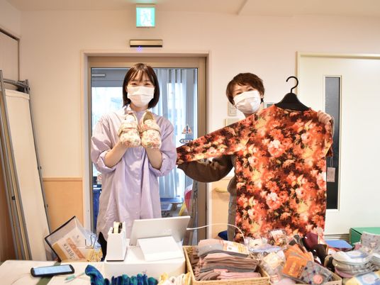 衣類を持つ職員の売り場  