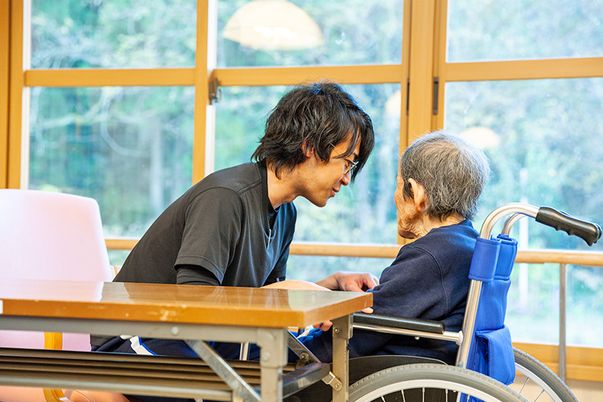 車椅子の高齢者と介護士の会話