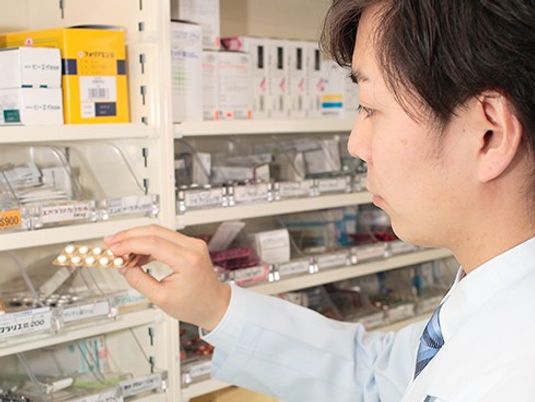 薬棚を確認するスタッフ  